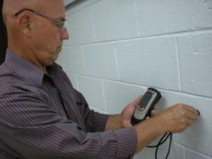 Photo 12 – Thickness of paint on a block wall being measured non-destructively.